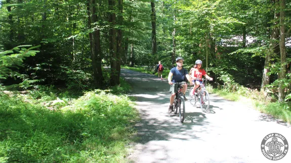 Scouts riding bicycles through camp